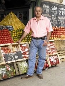 Man Standing by Fruit Kiosk